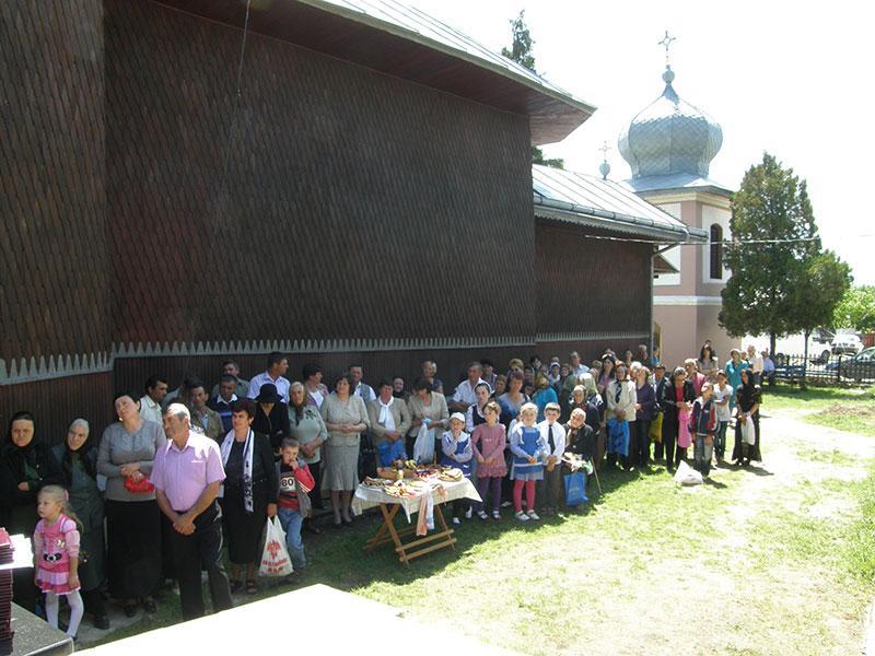 Credincioşii parohiei, participând la slujba sfinţirii altarului de vară